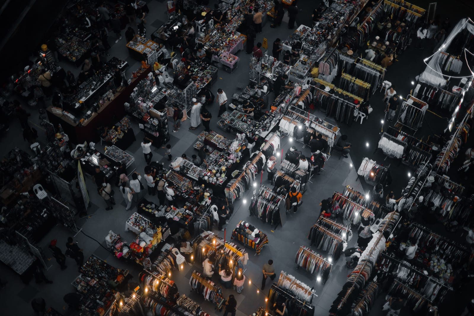 Aerial overhead view of a trade show floor with multiple vendor booths, display stands, and attendees.